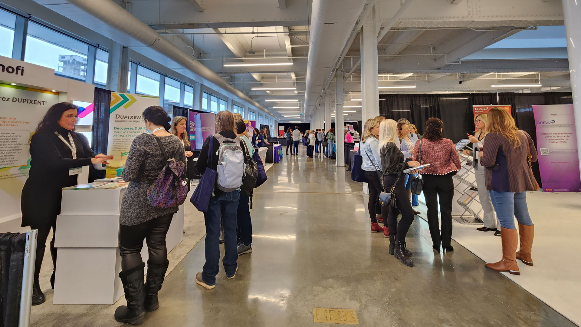 Allée des exposants avec participantes et participants